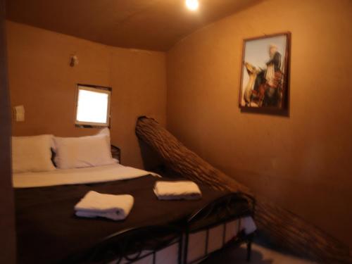 a bedroom with a bed with two towels on it at Tamaris Camp in Adrouine