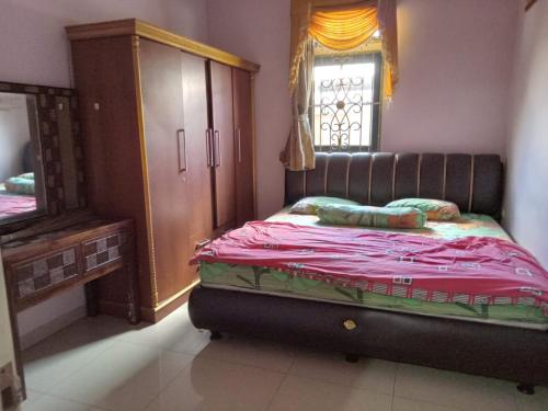 ein Schlafzimmer mit einem Bett mit einer Kommode und einem Spiegel in der Unterkunft Villa ilham in Cibadak