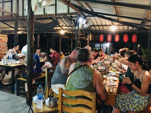 a group of people sitting at tables in a restaurant at Baan Sangchan in Ko Kood