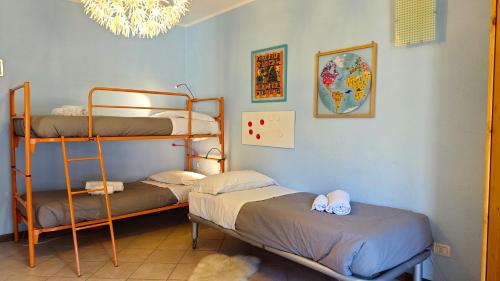 Pokój z 2 łóżkami piętrowymi i żyrandolem w obiekcie Hostdomus -Chalet Sciatori Garden w mieście Pragelato