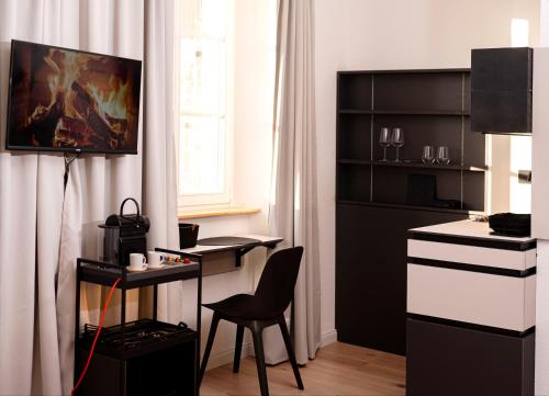 Zimmer mit einem Schreibtisch und einem Tisch mit einem Stuhl in der Unterkunft YokoLou - Design-Apartments in Koblenz