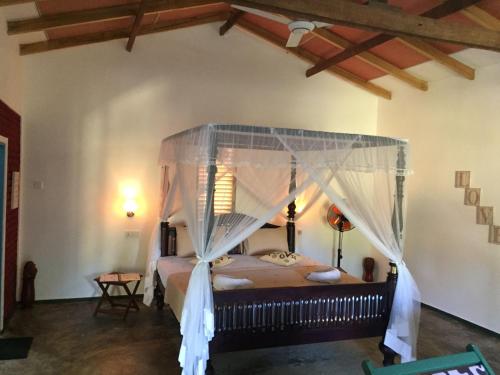 a bedroom with a bed with a canopy at Blue skies guest house and restaurant in Tangalle