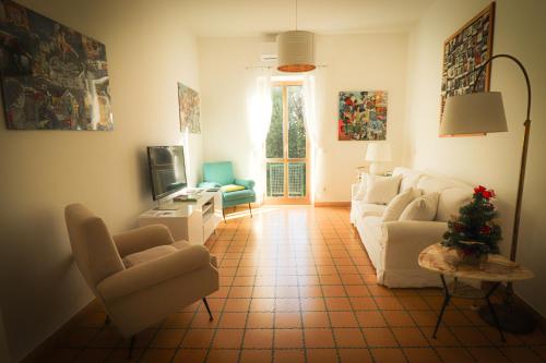 a living room with a white couch and chairs at Home Sweet Home in Vignanello