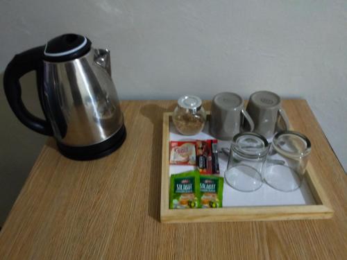 una mesa con cafetera y una bandeja con vasos en Sea u inn, en Romblon