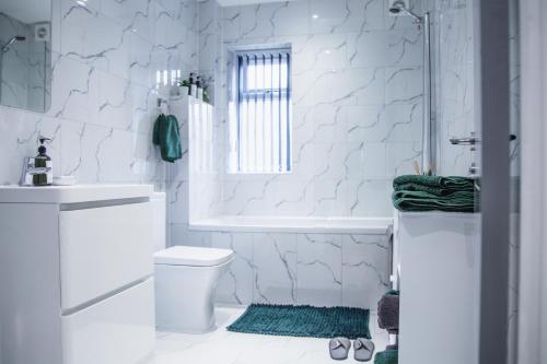 Baño blanco con aseo y lavamanos en Modern and Stylish 1 Bed Flat en High Wycombe