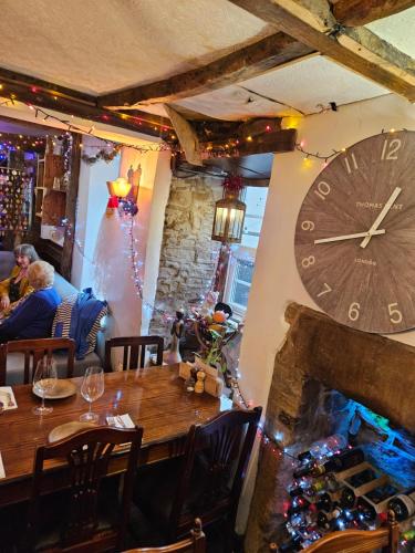 un comedor con un reloj grande en la pared en The Royal Oak Hotel, en Highpeak Junction