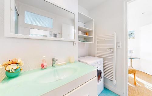 La salle de bains blanche est pourvue d'un lavabo et d'un miroir. dans l'établissement Amazing Apartment In Royan With Kitchen, à Royan