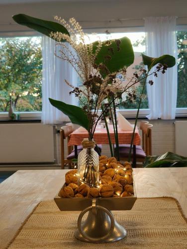a vase sitting on top of a table with a tray of nuts at Pension Skovly in Tranekær