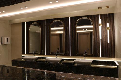 a row of sinks in a bathroom with five mirrors at Palma Beach Resort & Spa in Umm Al Quwain