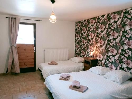 - 2 lits dans une chambre ornée de fleurs sur le mur dans l'établissement Õ 2040 Chambre Sapin, à Saint-Véran