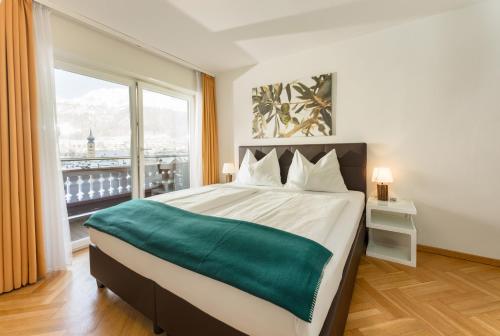 um quarto com uma cama grande e uma janela grande em Bella Vista Appartements by Schladming-Appartements em Schladming