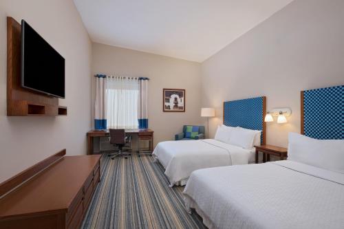 a hotel room with two beds and a flat screen tv at Four Points by Sheraton Monterrey Linda Vista in Monterrey