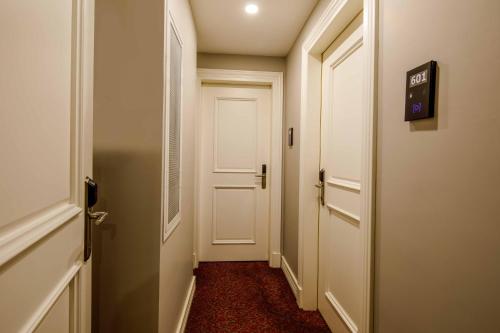 a hallway with a white door and a red floor at La Porte de Taksim in Istanbul