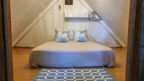 a bed with two pillows on it in a room at Charming Cabaña on the beach in Cambutal