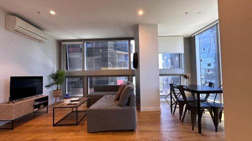 a living room with a couch and a table at Nest Apartments on Rose Lane in Melbourne