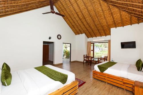 a bedroom with two beds and a tv at Heaven Hills Foresto ,Jim Corbett in Belparāo