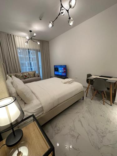 a bedroom with a bed and a desk with a laptop at Modern Home in Al Qurayyah