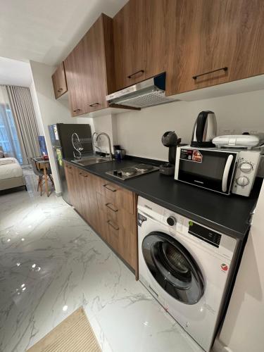 a kitchen with a washing machine and a microwave at Modern Home in Al Qurayyah