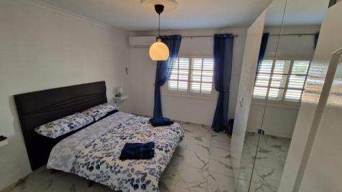 1 dormitorio con 1 cama y cortinas azules en The Palms Golf Del Sur - Casa Andromeda en San Miguel de Abona