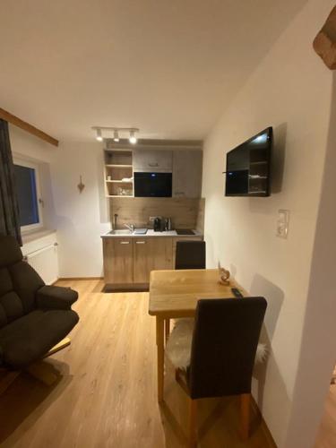 a living room with a table and a kitchen at Alpenappartements Schwalbennestl in Mittenwald