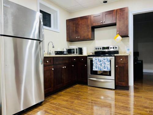 a kitchen with a stainless steel refrigerator and wooden cabinets at Gorgeous Apartment Serene Neighbourhood in Burlington