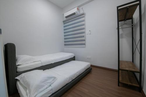 2 camas en una habitación pequeña con ventana en BB Condo Homestay, en Sandakan
