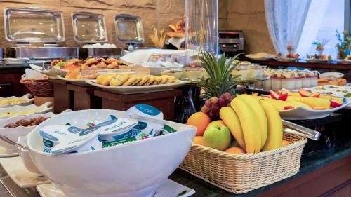 a buffet with bowls of fruit on a table at City Tower Hotel in Kuwait