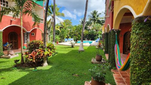 a resort yard with a pool and a surfboard at Casa Colonial Estate, Cozumel in Cozumel