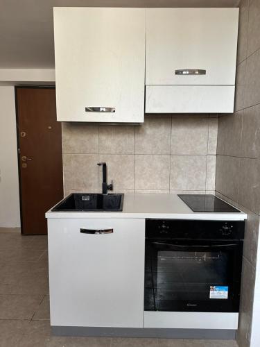 a white kitchen with a sink and a stove at Piccolo appartamento a Prato in Prato