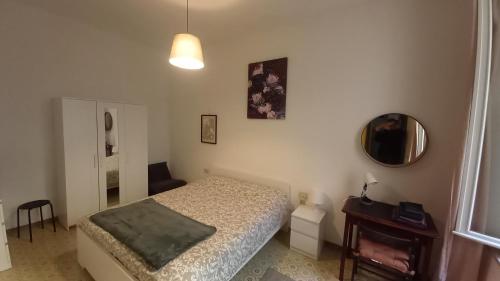 um quarto com uma cama e um espelho na parede em Console Camprini Rooms & Apartments - Parco Tassinari em Faenza