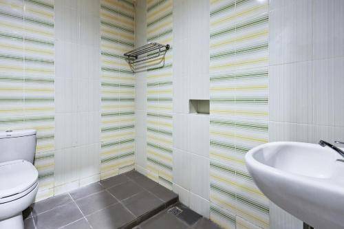 a bathroom with a toilet and a sink at Collection O 93163 Hotel Grand Kartika in Parepare