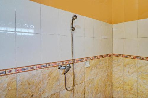 y baño con ducha y manguera. en OYO 93229 P3 Guest House, en Cilimus 2