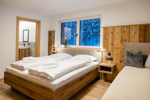 a bedroom with a large bed and a window at ANN SUITES Appartements in Filzmoos