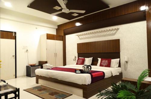 una camera da letto con un grande letto con cuscini rossi di Hotel Crown a Rajkot