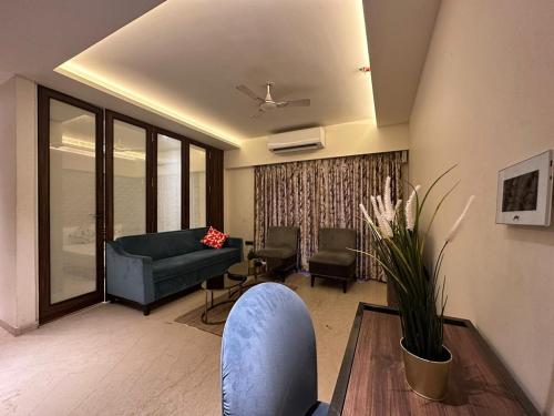 1.5BR Service apartment in BKC by Florastays في مومباي: غرفة معيشة مع أريكة وطاولة