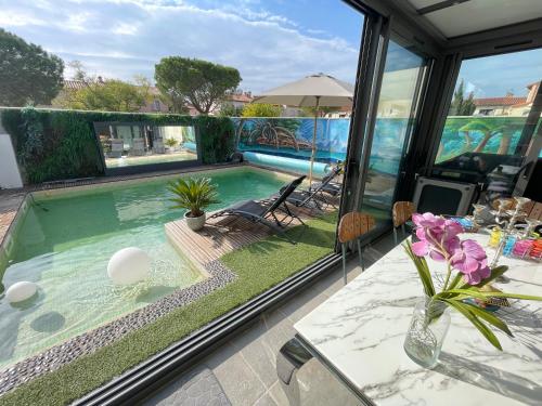 une maison avec une piscine et une table fleurie dans l'établissement Relaxation AquatiqueGarantie100%, à Saint-Estève