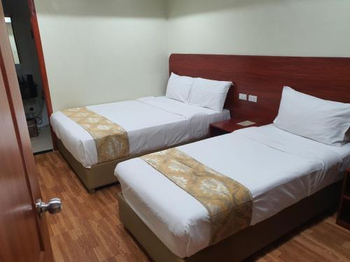 a hotel room with two beds and a door at 456 Hotel in Baguio