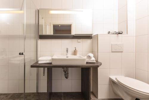 Bella Vista Appartements by Schladming-Appartements في سخلادميخ: حمام أبيض مع حوض ومرحاض