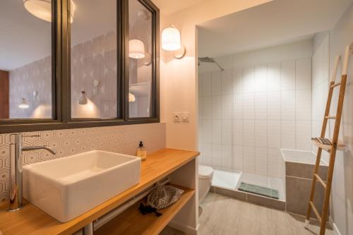 a bathroom with a sink and a toilet and a mirror at B&B La Maison de Julia in Albi