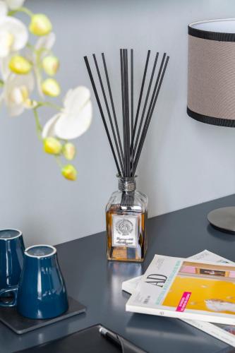 a table with a book and a vase with sticks at Flom Boutique Hotel in Florence