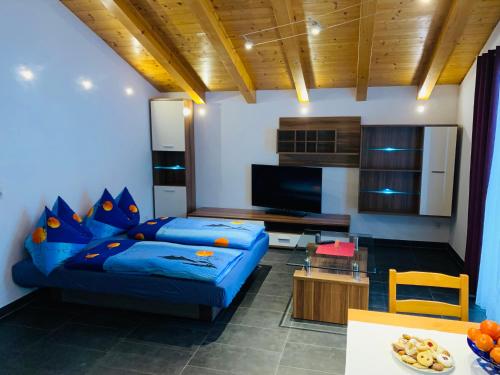 a living room with a blue couch and a tv at Appartement in Uttendorf