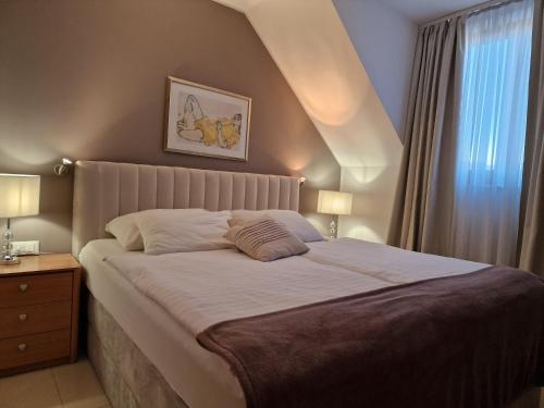 a bedroom with a large bed with a white bedspread at Aparthotel Gaja in Bled