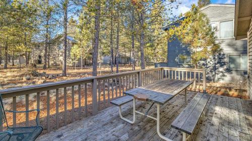 a wooden deck with a picnic table and chairs on it at Big Leaf - Unit 6 in Sunriver