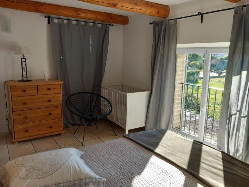 une chambre avec un lit, une commode et une fenêtre dans l'établissement Cuisine, chambres et salle de bains indépendants, à Saint-Christol-lès-Alès