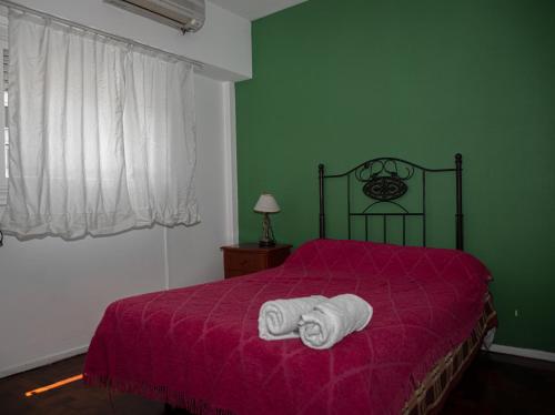 1 dormitorio con 1 cama con manta morada en Dos ambientes en Palermo (La Rural) en Buenos Aires