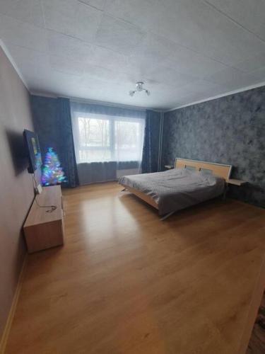 a bedroom with a bed and a christmas tree in it at Salaspils Apartament 2023 in Salaspils