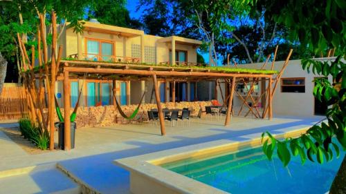 una casa con terrazza accanto a una piscina di Azul Maria Bacalar a Bacalar