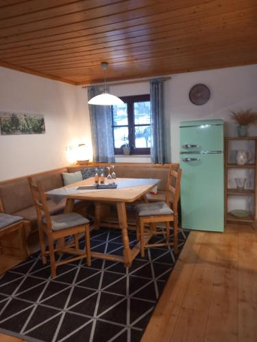a dining room with a table and a green refrigerator at S'Rastl direkt mit Bergpanorama in Grundlsee