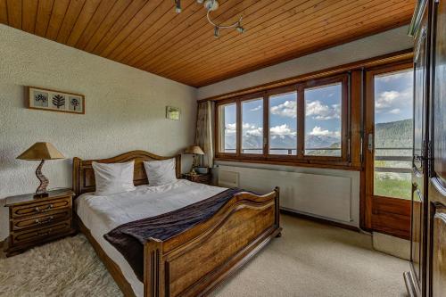 a bedroom with a bed and a large window at Appartement Arolles 701 in La Tzoumaz
