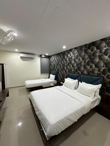 a bedroom with a large bed and a wall at HOTEL GOLDEN VIEW in Vadodara